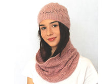 Load image into Gallery viewer, A young woman faces the camera. She has long dark hair and a white shirt is wearing a dusky pink lacey beanie and cowl. The background is white.
