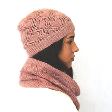 Load image into Gallery viewer, The side view of a young woman. She has long dark hair and a white shirt is wearing a dusky pink lacey beanie and cowl. The background is white.
