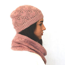 Load image into Gallery viewer, The side view of a young woman. She has long dark hair and a white shirt is wearing a dusky pink lacey beanie and cowl. The background is white.