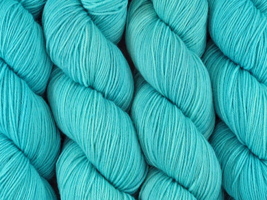 A close up of semi-solid light bright aqua blue coloured skeins of superwash merino and nylon 4ply fingering sock yarn (Aqualung on Tough Stocking)