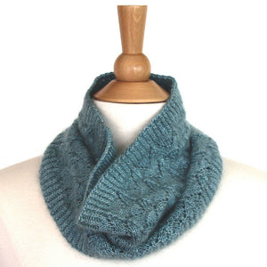 A pale blue-green fishtail lace cowl sits around the neck of a mannequin, standing against a white background.