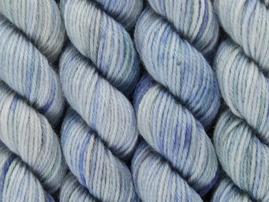 A close up of variegated white, mauve blue and sea green coloured skeins of superwash merino and nylon 4ply fingering sock yarn (Blue Steel on Tough Stocking)