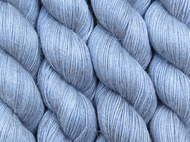 A close up of semi-solid grey with hints of silver, graphite and steel blue coloured skeins of non-superwash baby alpaca, silk and linen 4ply fingering weight yarn (Fog Bound on Spinifex)