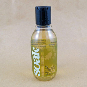 One small bottle of Soak rinse-free laundry liquid with a green label, on a tan background (Fig scent)
