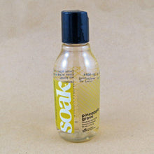 Load image into Gallery viewer, One small bottle of Soak rinse-free laundry liquid with a yellow label, on a tan background (Pineapple Grove scent)