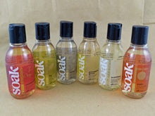 Load image into Gallery viewer, Six small bottles of Soak rinse-free laundry liquid arranged in a semi-circle on a tan background