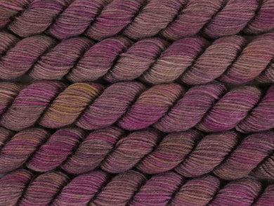 A close up of variegated brown, beige-grey, pink, purple and yellow mini skeins of superwash merino and nylon 4ply fingering sock yarn arranged horizontally (Boronia on Tough Stocking Mini)