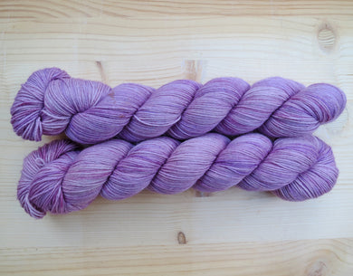 A close up of mauve tonal coloured skeins of superwash merino and nylon 4ply fingering sock yarn (One Hit Wonder 2 on Tough Stocking)