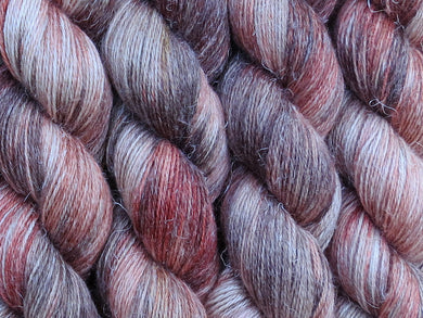 A close up of variegated rust, chocolate, tan and beige coloured skeins of non-superwash baby alpaca, silk and linen 4ply fingering weight yarn (River Red Gum on Spinifex)