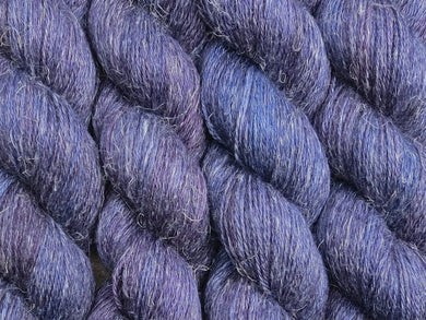 A close up of semi-solid dark blue, midnight blue, deep red-purple and maroon coloured skeins of non-superwash baby alpaca, silk and linen 4ply fingering weight yarn (Round Midnight on Spinifex)