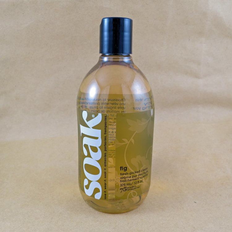 One large bottle of Soak rinse-free laundry liquid with a green label, on a tan background (Fig scent)
