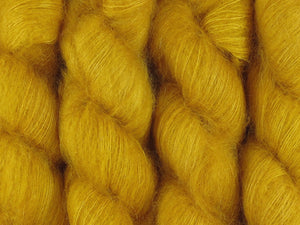 A close up of semi-solid deep golden yellow coloured skeins of superfine kid mohair and silk 2ply lace yarn (Turmeric on Kid Glove Lace)