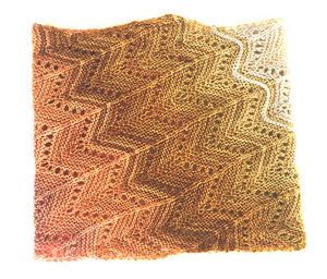 A multi coloured lace knitted cowl in shades of cream, coral and tan lying on a white background. Pattern is Adventurer Cowl by Ambah O'Brien