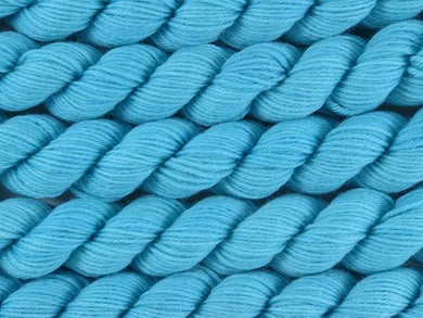 A close up of semi-solid light bright aqua blue mini skeins of superwash merino and nylon 4ply fingering sock yarn arranged horizontally (Aqualung on Tough Stocking Mini)