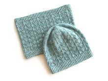 Load image into Gallery viewer, A pale blue-green fishtail lace beanie sits partly on top of a matching lace cowl, on a white background.
