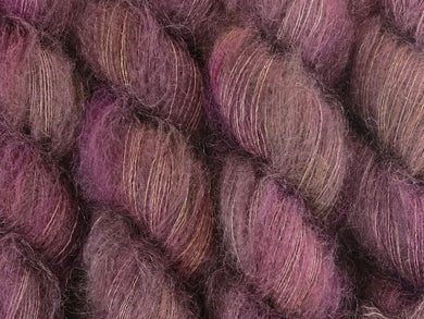 A close up of variegated brown, beige-grey, pink, purple and yellow coloured skeins of superfine kid mohair and silk 2ply lace yarn (Boronia on Kid Glove Lace)