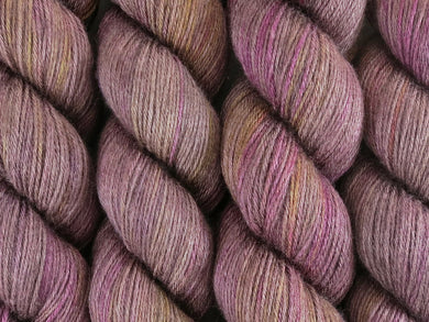 A close up of variegated brown, beige-grey, pink, purple and yellow coloured skeins of superwash merino and silk 4ply fingering sock yarn (Boronia on Silk Stocking)