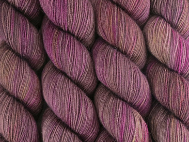 A close up of variegated brown, beige-grey, pink, purple and yellow coloured skeins of superwash merino and nylon 4ply fingering sock yarn (Boronia on Tough Stocking)
