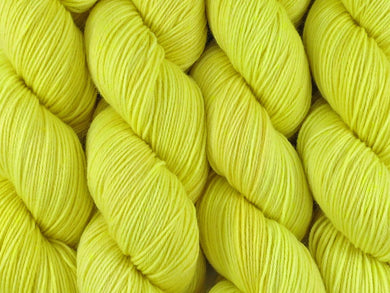 A close up of semi-solid light bright lemon yellow with hints of neon yellow and gold coloured skeins of superwash merino and nylon 4ply fingering sock yarn (Sherbet Lemon on Tough Stocking)