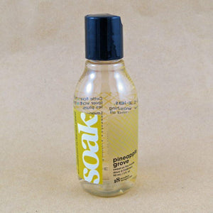 One small bottle of Soak rinse-free laundry liquid with a yellow label, on a tan background (Pineapple Grove scent)