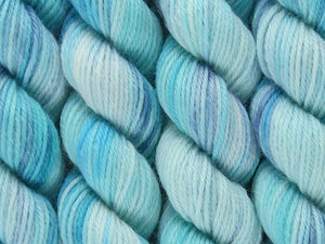 A close up of variegated aqua and white with hints of navy blue coloured skeins of superwash merino and nylon 4ply fingering sock yarn (Tiffany Blues on Tough Stocking)