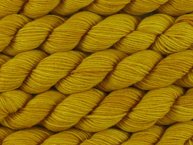 A close up of semi-solid deep golden yellow mini skeins of superwash merino and nylon 4ply fingering sock yarn arranged horizontally (Turmeric on Tough Stocking Mini)