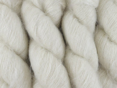 A close up of natural warm white coloured skeins of superfine kid mohair and silk 2ply lace yarn (Undyed on Kid Glove Lace)