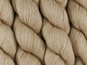 A close up of undyed warm tan  coloured skeins of baby camel and silk 2ply lace weight yarn (Undyed on Camel Train Lace)