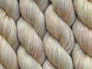 A close up of variegated light golden yellow with hints of rust, maroon and grey coloured skeins of non-superwash baby alpaca, silk and linen 4ply fingering weight yarn (Yellowblock on Spinifex)